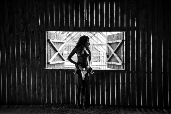 Antemortem, a figure holding a ram's skull in a dark barn